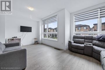 Barrie (Innis-Shore) townhouse for rent - A living room with a grey couch and a flat screen TV mounted on the wall.