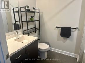 Oakville (Jm Joshua Meadows) condo for rent - A bathroom with a sink, toilet, and shelves with plants.