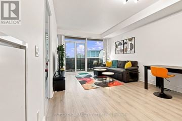 Toronto (Mimico) condo for rent - A living room with a black couch and a yellow chair.