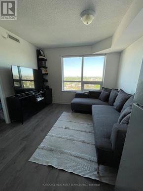 Toronto (Dovercourt-Wallace Emerson-Junction) condo for rent - A living room with a grey couch and a television.