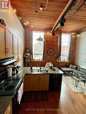 Guelph (St. Patrick's Ward) condo for rent - A kitchen with wooden cabinets and a black stove top oven.