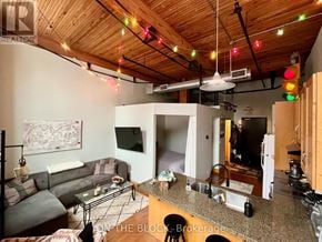 Guelph (St. Patrick's Ward) condo for rent - A living room with a couch, a coffee table, and a television.