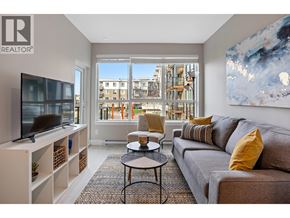 Tsawwassen apartment for rent - A living room with a grey couch, a black coffee table, a television, and a large window with a view of a building.