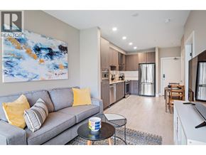 Tsawwassen apartment for rent - A living room with a grey couch and a painting on the wall.