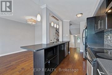Aurora (Bayview Wellington) townhouse for rent - A kitchen with a black counter top and wooden floors.