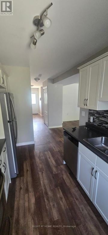 Kingston (City Northwest) townhouse for rent - A kitchen with white cabinets and a wooden floor.