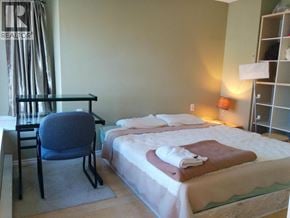 Richmond townhouse for rent - A bedroom with a bed, chair, and nightstand.