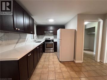 Brantford apartment for rent - A kitchen with a refrigerator, oven, and cabinets.