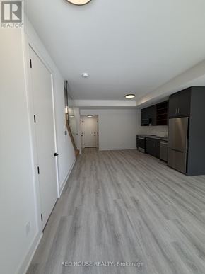 St. Catharines (Oakdale) townhouse for rent - A long hallway with a kitchen area at the end.