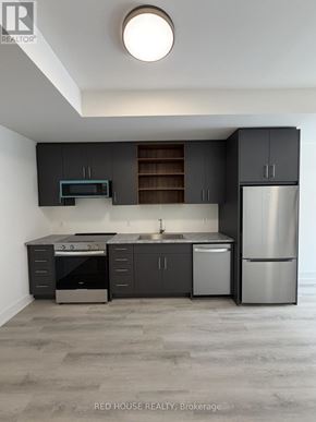 St. Catharines (Oakdale) townhouse for rent - A modern kitchen with dark grey cabinets and stainless steel appliances.