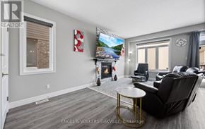 Woodstock (Woodstock - North) townhouse for rent - A living room with a fireplace and a painting of a beach scene on the wall.