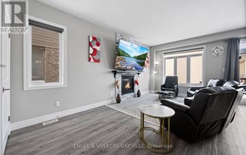 Woodstock (Woodstock - North) townhouse for rent - A living room with a fireplace and a painting of a beach scene on the wall.