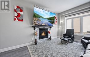 Woodstock (Woodstock - North) townhouse for rent - A living room with a fireplace and a television on the wall.