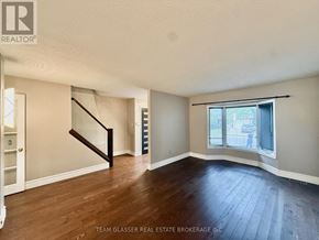 London South (South X) apartment for rent - A room with wooden floors and a staircase leading to another room.