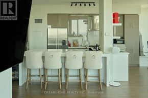 Mississauga (City Centre) condo for rent - A modern kitchen with white chairs and a wooden table.