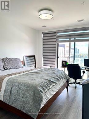 Cambridge condo for rent - A bedroom with a bed, a chair, and a window with blinds.