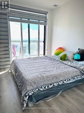 Cambridge condo for rent - A bedroom with a large bed and a view of the ocean through the window.