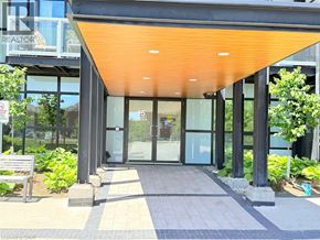 Kitchener condo for rent - The entrance to a building with a glass door and a bench in front.