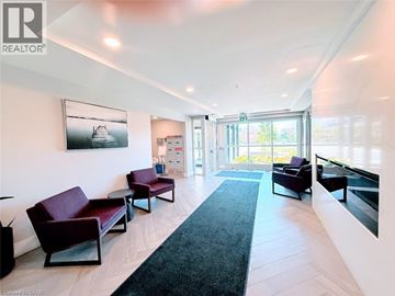 Kitchener condo for rent - A living room with a black rug and a painting of a boat on the wall.