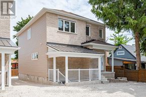 Oshawa (Mclaughlin) triplex for rent - A house with a porch and a tree in front.