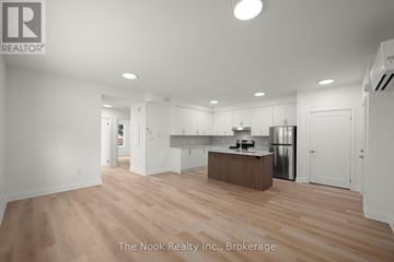 Oshawa (Mclaughlin) triplex for rent - A spacious kitchen with white cabinets and a wooden island.