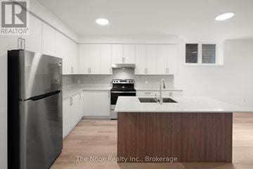 Oshawa (Mclaughlin) triplex for rent - A modern kitchen with a stainless steel refrigerator and wooden island.