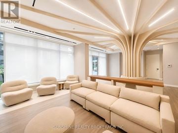 Toronto (Regent Park) condo for rent - A living room with a large couch and a long table.