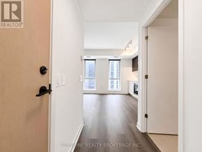 Toronto (Regent Park) condo for rent - A hallway with a door on the left and a window on the right.