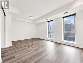 Toronto (Regent Park) condo for rent - A spacious room with wooden flooring and white walls.