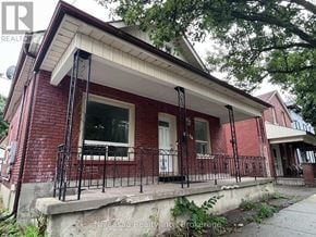 Brantford apartment for rent - A red brick house with a white door and a black iron railing.