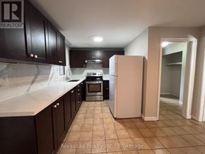 Brantford apartment for rent - A kitchen with a refrigerator, oven, and cabinets.