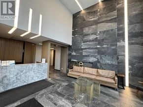Toronto (Islington-City Centre West) condo for rent - A reception area with a marble counter and a stone wall.