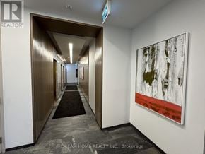 Toronto (Islington-City Centre West) condo for rent - A hallway with a painting on the wall and a brokerage logo on the floor.