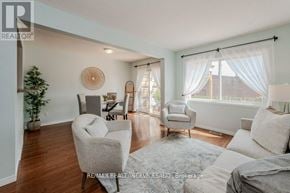 Cambridge townhouse for rent - A living room with a grey sofa, a white armchair, and a wooden floor.