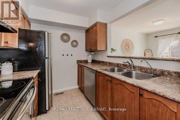 Cambridge townhouse for rent - A kitchen with a black refrigerator, wooden cabinets, and a granite countertop.