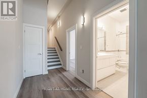 Toronto (Clairlea-Birchmount) apartment for rent - A bathroom with a toilet, sink, and mirror is visible through an open door.