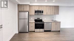 Toronto (Humber Heights) condo for rent - A modern kitchen with a refrigerator, oven, microwave, and sink.