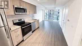Toronto (Humber Heights) condo for rent - A kitchen with a refrigerator, oven, and microwave.