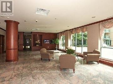 Toronto (Willowdale East) condo for rent - A living room with a brown column and a couch.