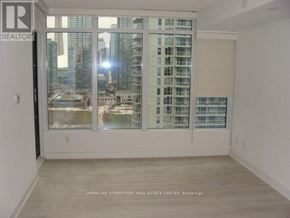 Toronto (Waterfront Communities) condo for rent - A room with a large window overlooking a cityscape.