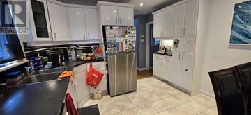 Toronto (Newtonbrook West) apartment for rent - A kitchen with white cabinets and a black counter top.