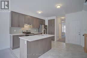 Oshawa (Kedron) townhouse for rent - A kitchen with a white counter top and brown cabinets.