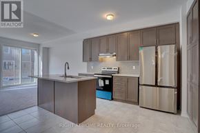 Oshawa (Kedron) townhouse for rent - A kitchen with a refrigerator, sink, and cabinets.