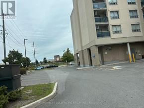 Aurora (Aurora Village) condo for rent - A parking lot in front of a building with a sign that says "HOMELIFE GOLD PACIFIC REALTY INC., Brokerage".