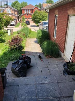 Halton Hills (Georgetown) apartment for rent - A red brick house with a white door and a black trash bag on the ground.