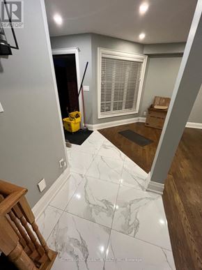 Halton Hills (Georgetown) apartment for rent - A hallway with a marble floor and a wooden staircase.