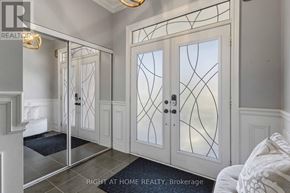 Oshawa (Taunton) apartment for rent - A hallway with a glass door and a chandelier.