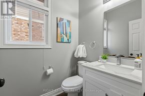 Oshawa (Taunton) apartment for rent - A bathroom with a toilet, sink, and mirror.