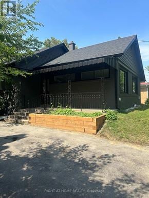 Mississauga (Clarkson) apartment for rent - A house with a black roof and a wooden planter box in front.
