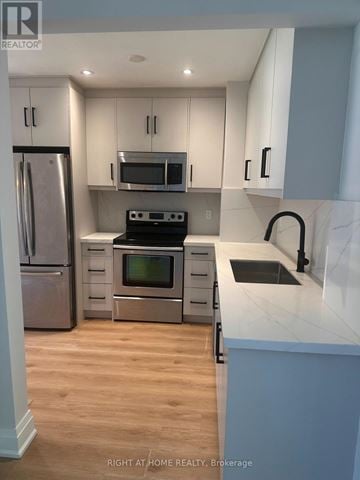 Mississauga (Clarkson) apartment for rent - A kitchen with a stove top oven and microwave above it.